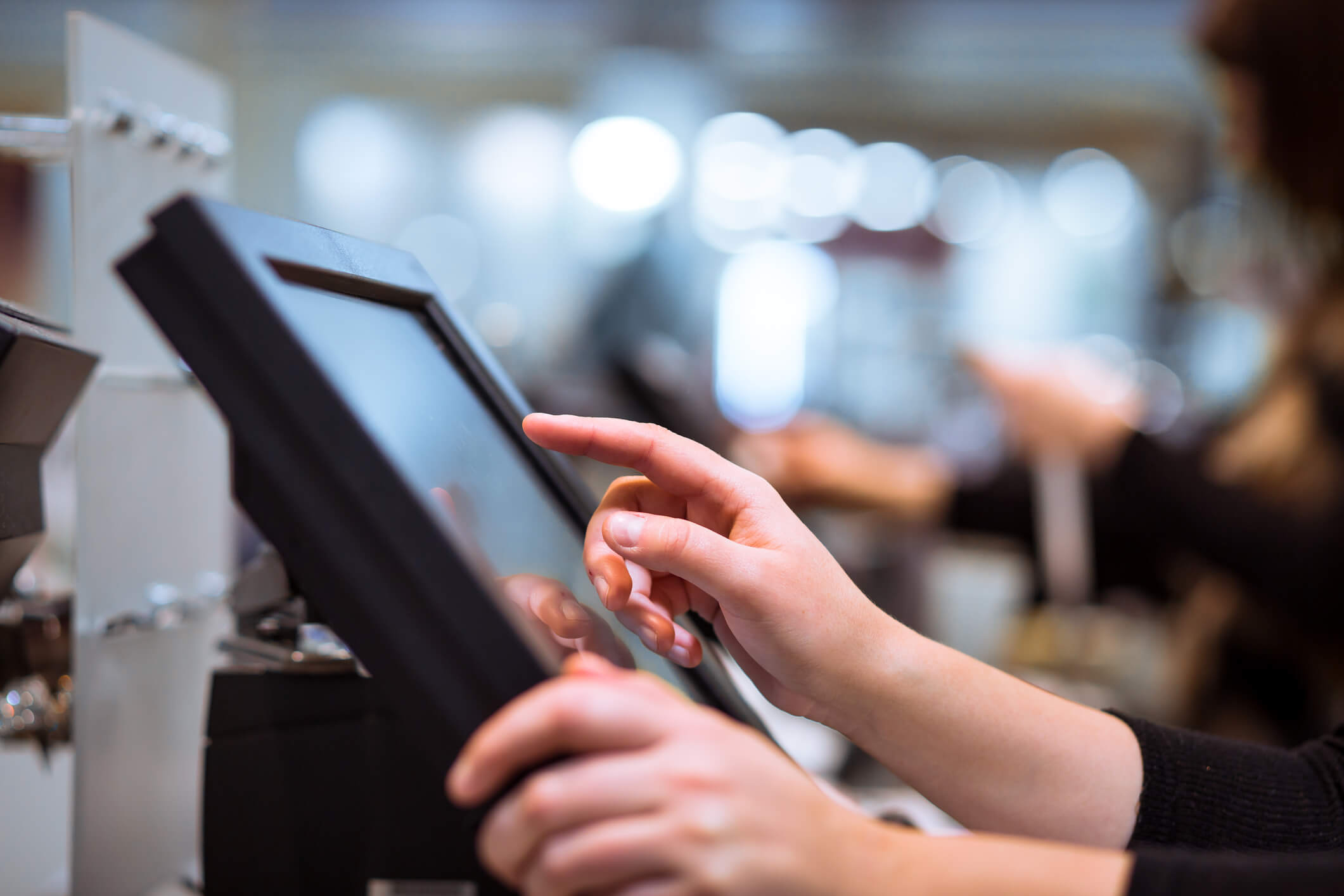 Young woman hand doing process payment on a touchscreen cash register, POS
